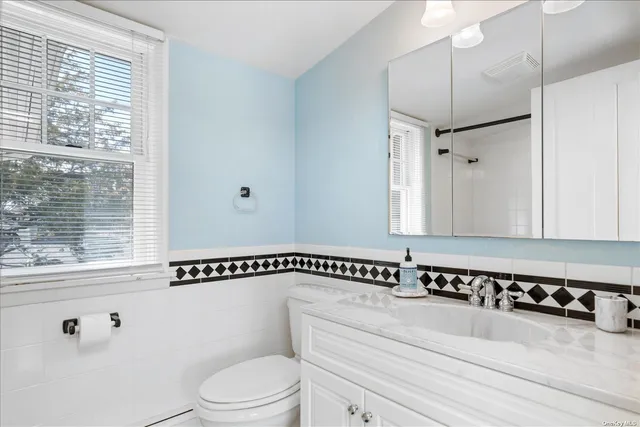 a bathroom with a sink a toilet and a mirror