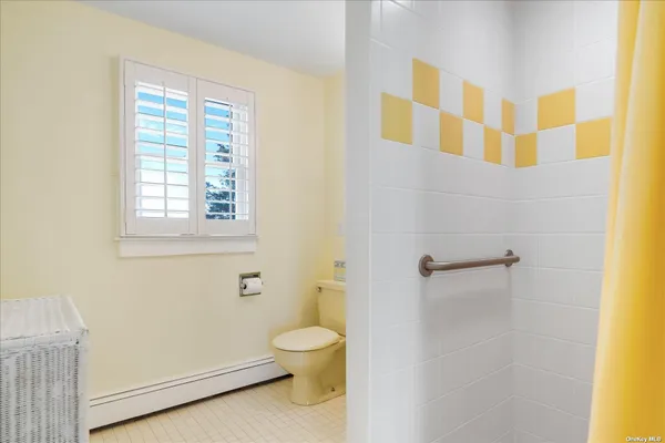 a bathroom with a toilet and a shower
