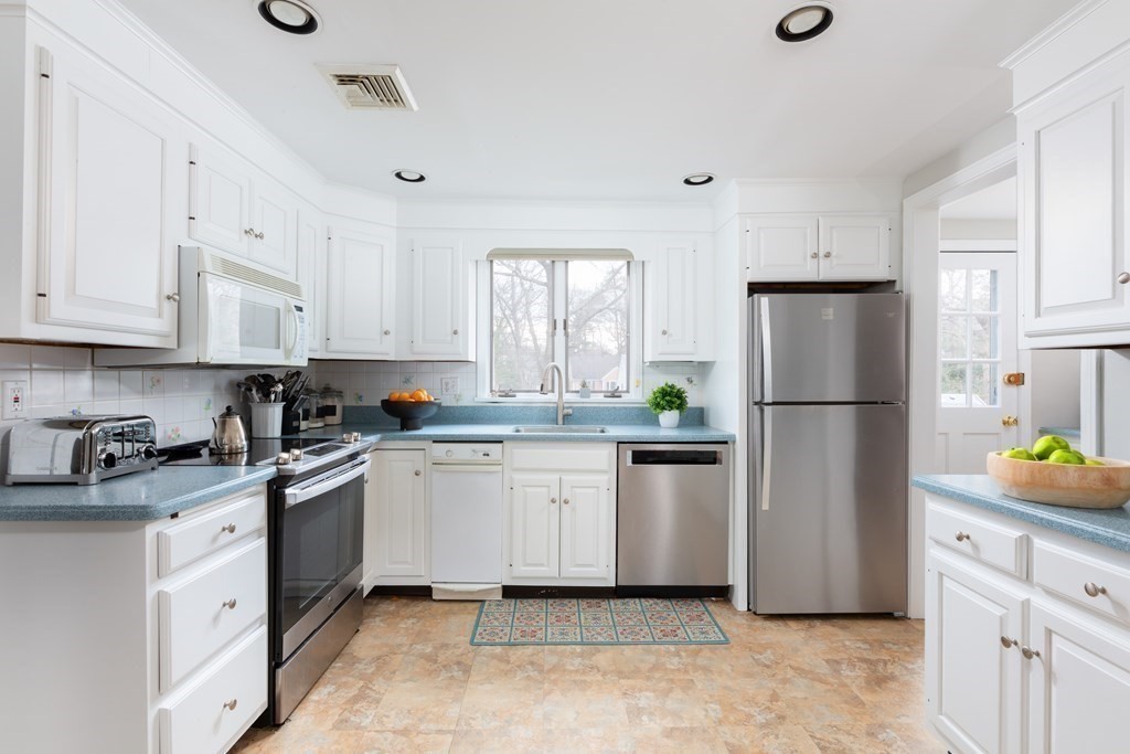 113 Payson Road Brookline, MA 02467 - Photo 7 of 16 a kitchen with white cabinets stainless steel appliances and a sink
