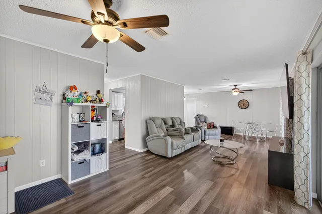 a living room with furniture and a wooden floor