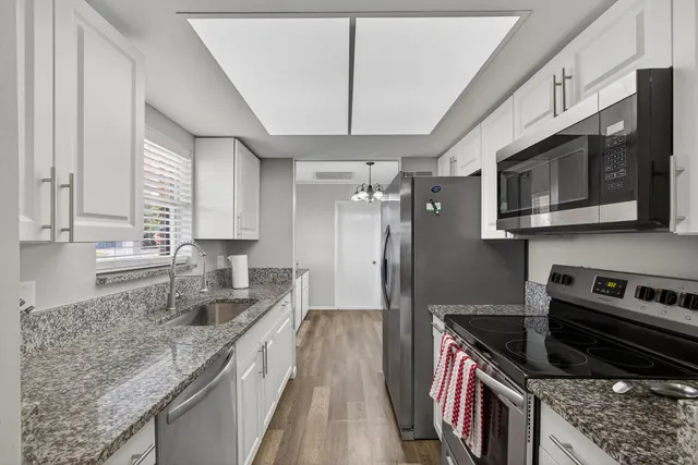 a kitchen with stainless steel appliances granite countertop a stove microwave and refrigerator