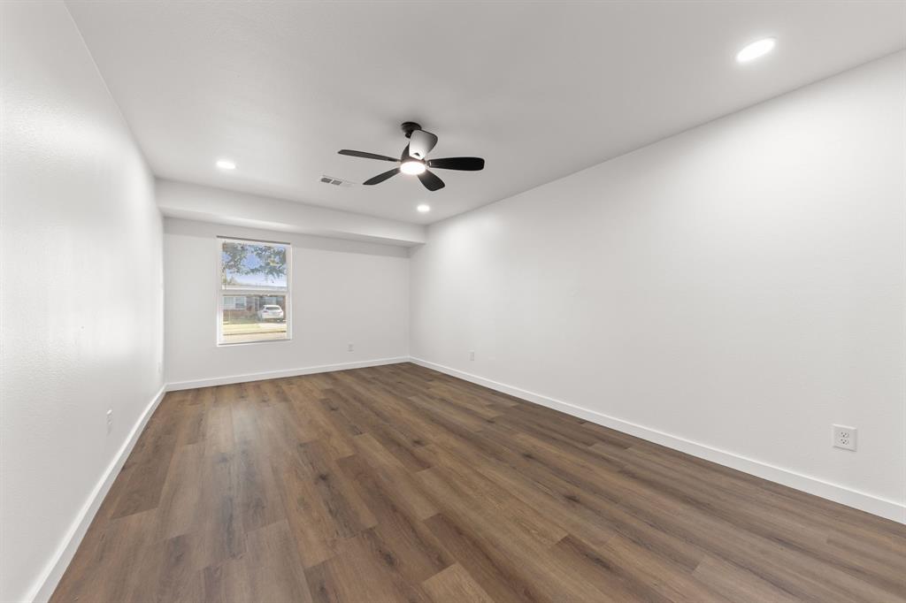 3227 Mayhew Drive Dallas, TX 75228 - Photo 14 of 25 an empty room with wooden floor and windows
