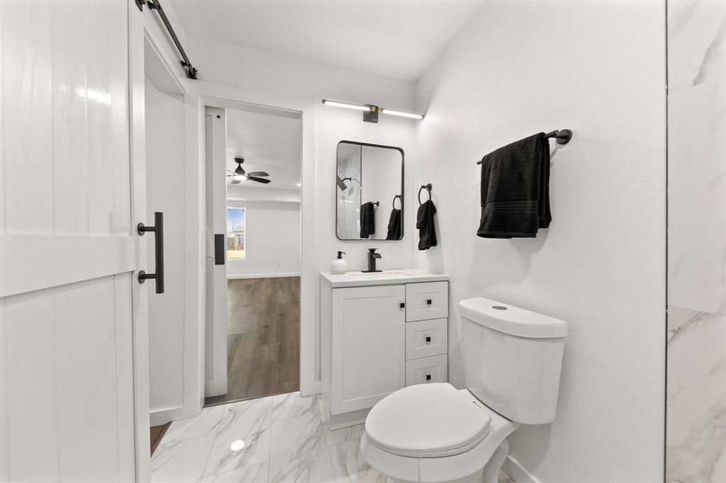 3227 Mayhew Drive Dallas, TX 75228 - Photo 17 of 25 a bathroom with a toilet a sink and mirror