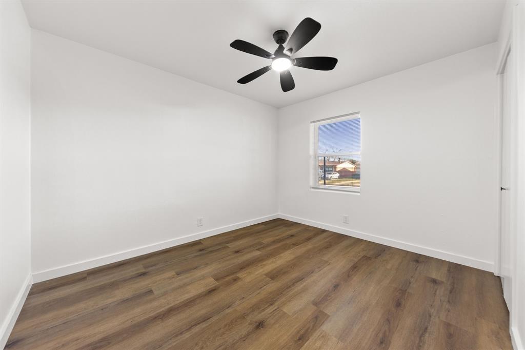 3227 Mayhew Drive Dallas, TX 75228 - Photo 19 of 25 an empty room with wooden floor and ceiling fan