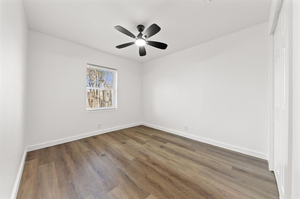 3227 Mayhew Drive Dallas, TX 75228 - Photo 20 of 25 an empty room with wooden floor ceiling fan and window