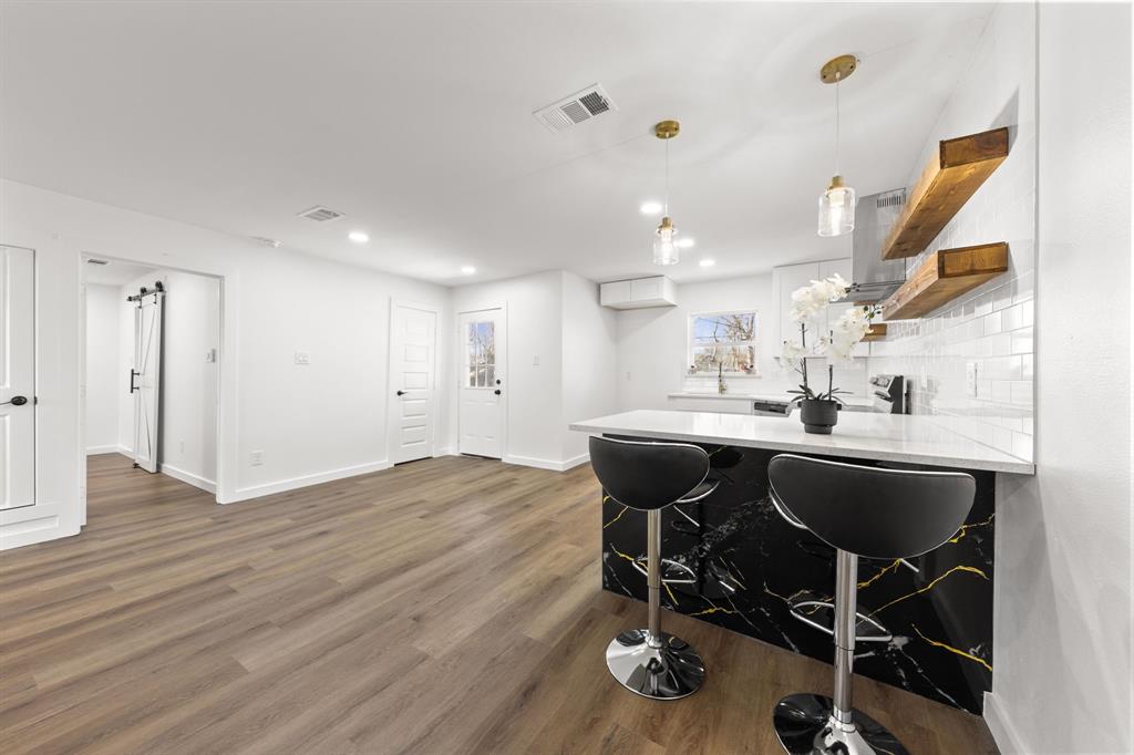3227 Mayhew Drive Dallas, TX 75228 - Photo 9 of 25 a kitchen with stainless steel appliances kitchen island a island sink and cabinets