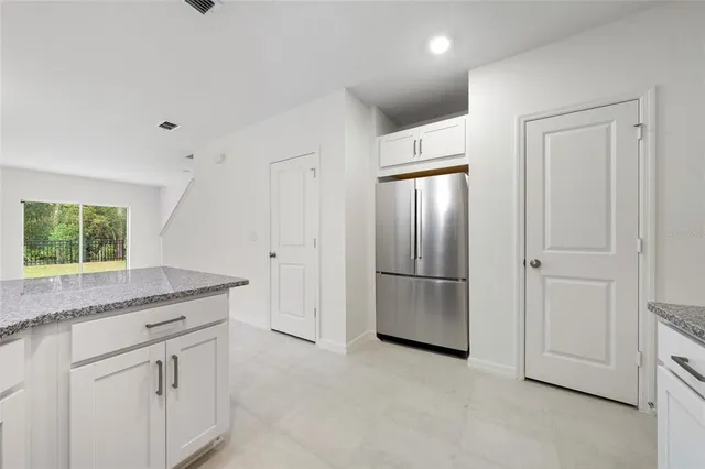 a kitchen with a refrigerator and countertop cabinets