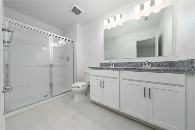 a bathroom with a granite countertop sink toilet and shower