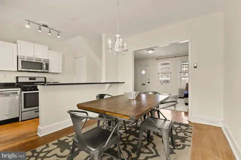 a kitchen with stainless steel appliances a dining table chairs and granite counter tops