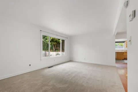 an empty room with staircase and windows