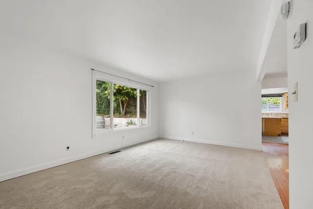 an empty room with staircase and windows