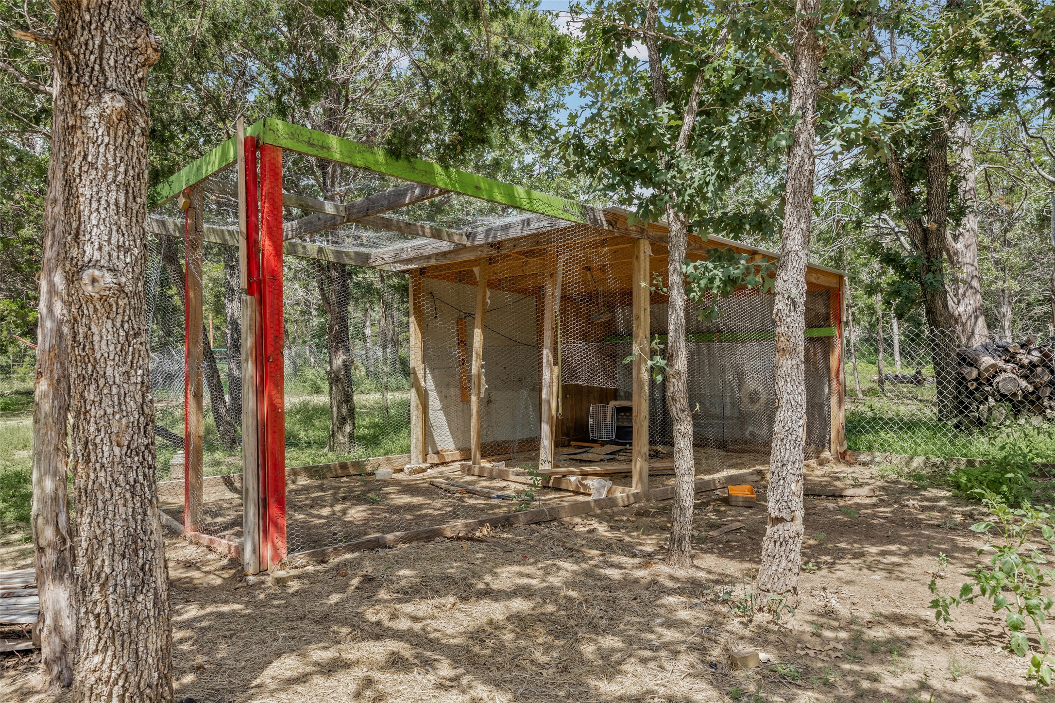 564 Boyd Road Red Rock, TX 78662 - Photo 12 of 25 A fenced enclosure nestled amongst mature trees, ideal for pets or livestock.