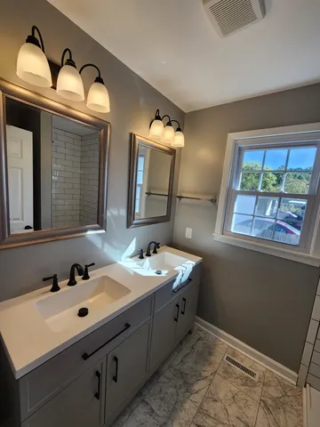 a bathroom with a double vanity sink and a mirror