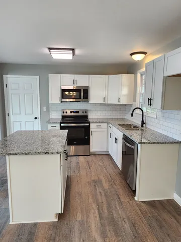 a kitchen with granite countertop a sink and steel appliances