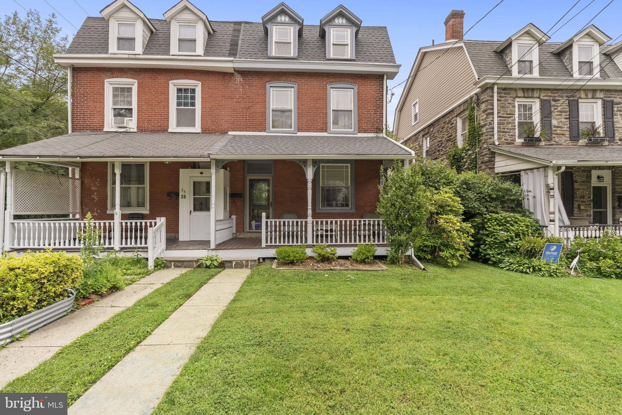 front view of a brick house with a yard