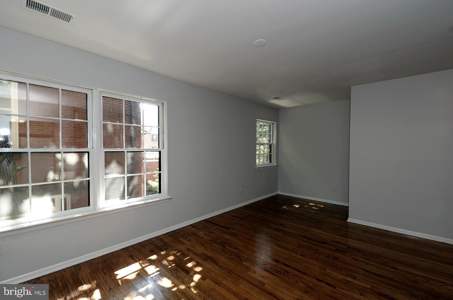 1730 16th Street Northwest, Unit 14 Washington, DC 20009 - Photo 6 of 17 a view of an empty room with wooden floor and a window