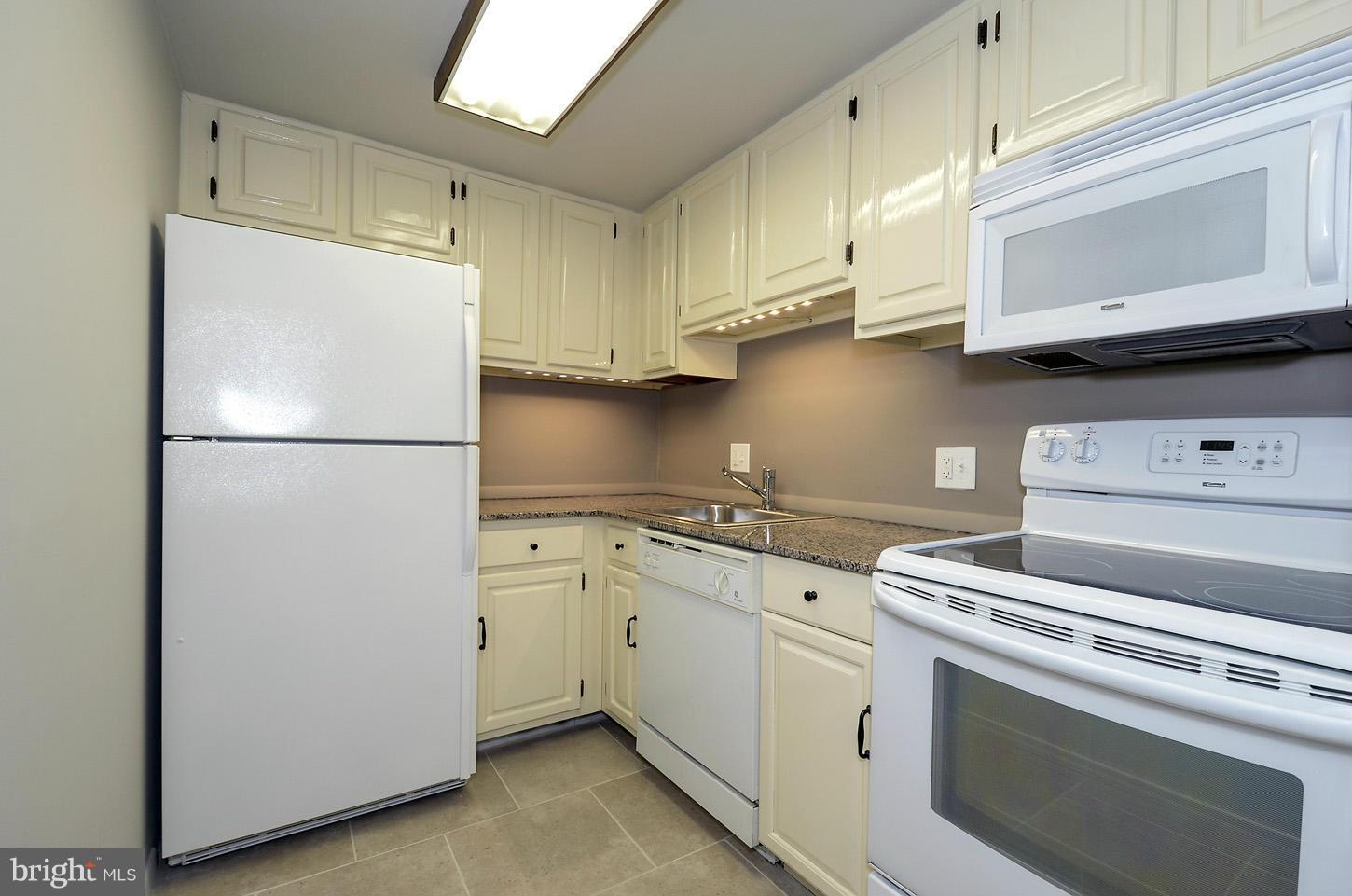 1730 16th Street Northwest, Unit 14 Washington, DC 20009 - Photo 10 of 17 a kitchen with stainless steel appliances white cabinets and a refrigerator