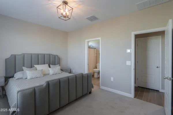 a bedroom with a bed and a chandelier