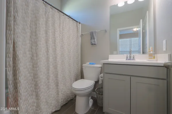 a bedroom with a bed and a chandelier fan