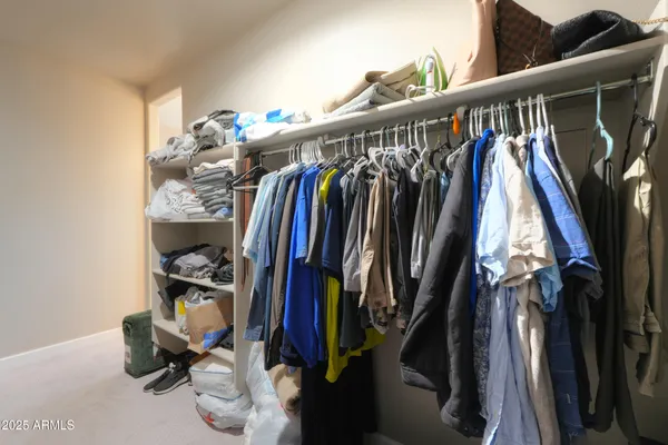 a view of walk in closet with clothes and shoes