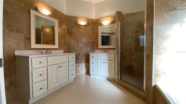 a bathroom with a double vanity sink a mirror and a shower