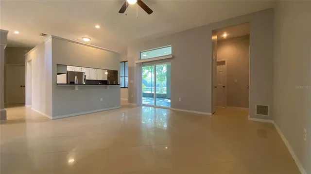 a view of a livingroom with kitchen and window
