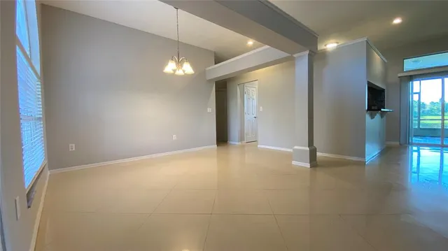 a view of an empty room with glass door and windows