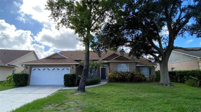 a front view of a house with a garden and trees
