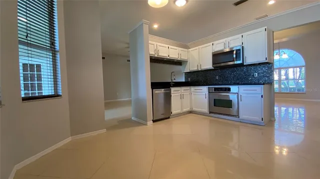 a kitchen with stainless steel appliances granite countertop a stove top oven a sink and a microwave