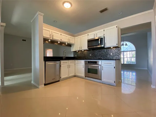 a large kitchen with stainless steel appliances granite countertop a stove and a sink