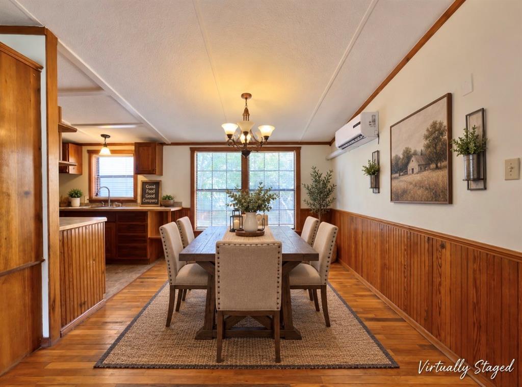 4676 Old Dallas Road Elm Mott, TX 76640 - Photo 5 of 21 Wood-finish flooring, wood paneling, wood-frame windows, and a multi-light chandelier
