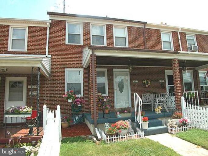 front view of a brick house with a yard
