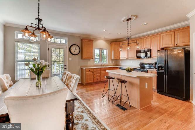 5136 Key View Way Perry Hall, MD 21128 - Photo 11 of 28 a kitchen with stainless steel appliances granite countertop a stove a refrigerator a oven a sink a dining table and chairs with wooden floor