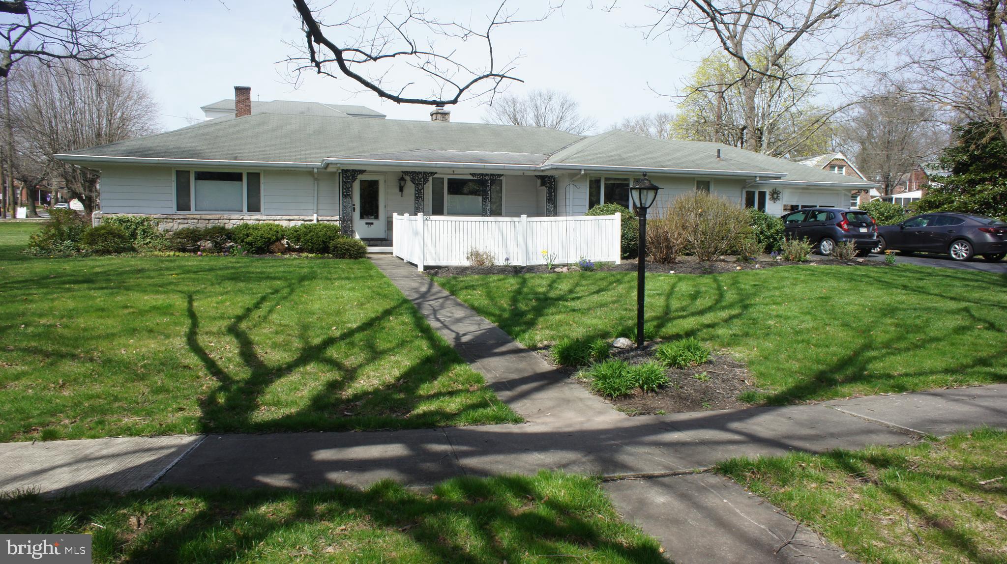 a front view of a residential houses with yard and green space