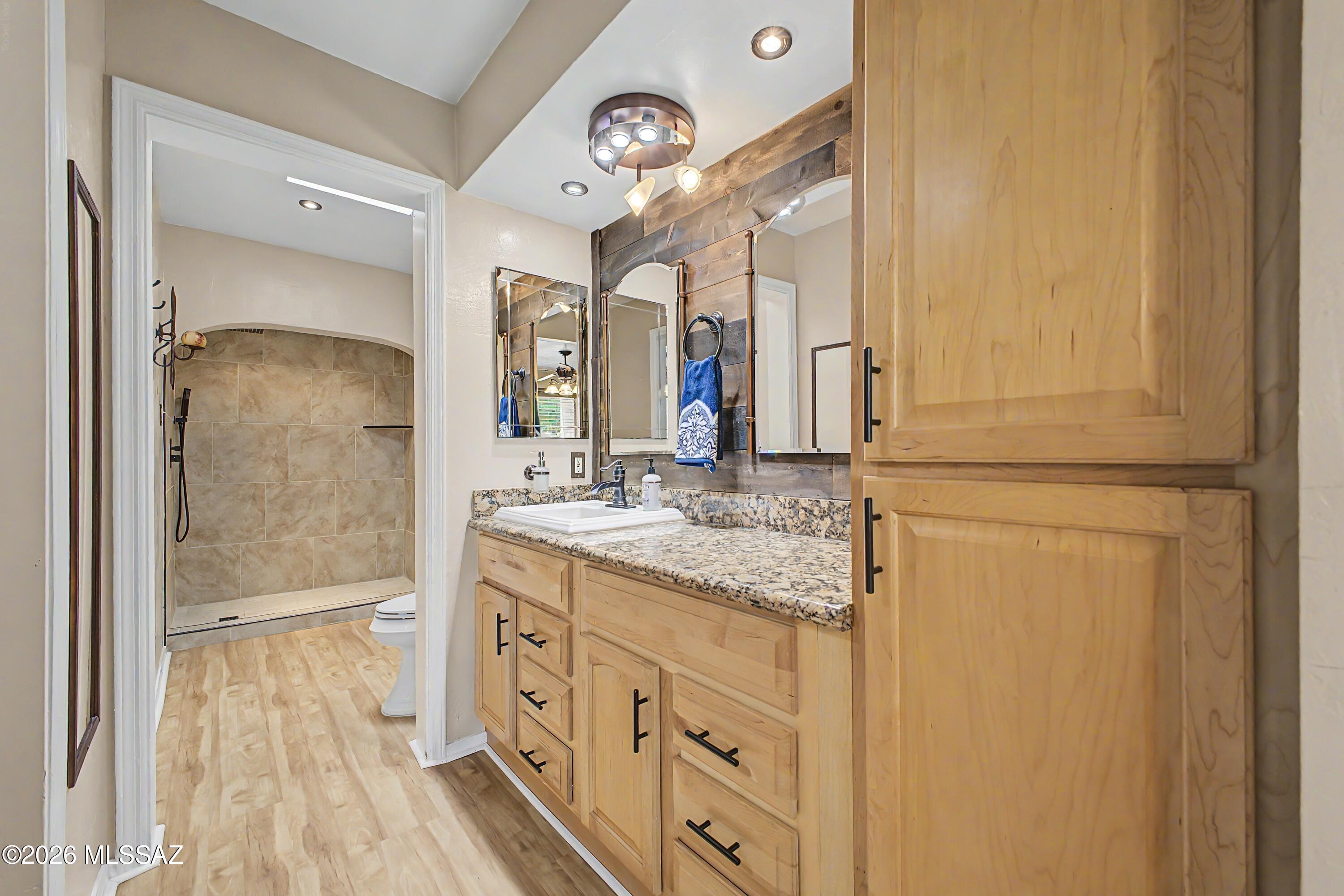 3781 East Edison Street Tucson, AZ 85716 - Photo 18 of 28 a bathroom with a granite countertop sink and a mirror