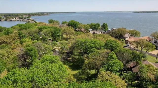 an aerial view of a house with a yard and lake view
