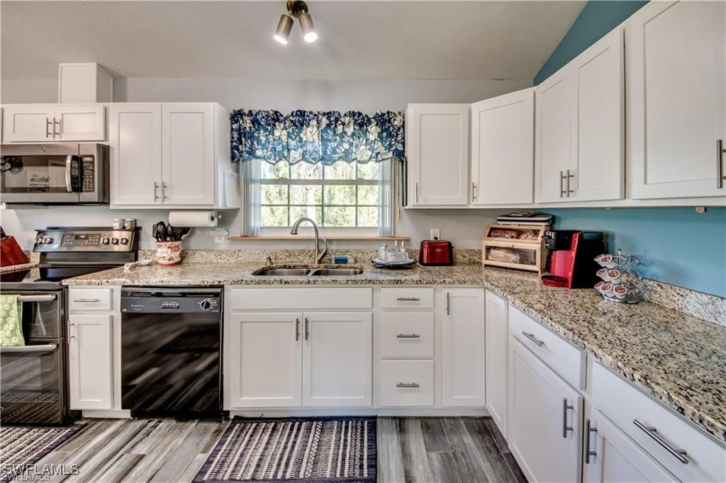 10796 Russell Road Bokeelia, FL 33922 - Photo 11 of 47 a kitchen with stainless steel appliances granite countertop a stove sink and cabinets