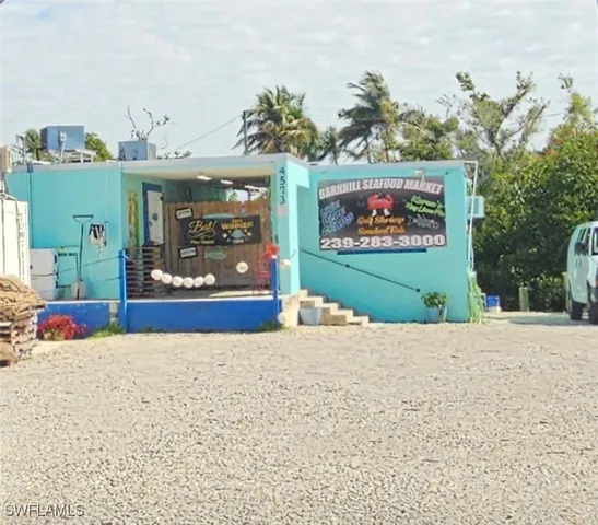 a front view of a multi story residential apartment building with a garden and plants