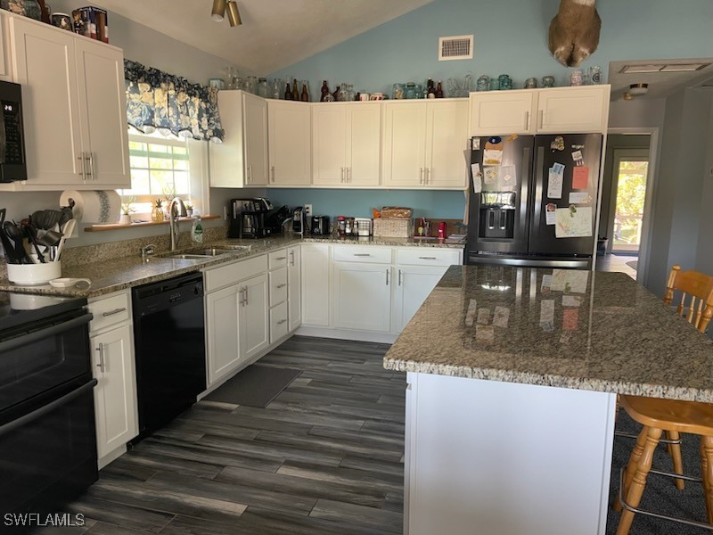 10796 Russell Road Bokeelia, FL 33922 - Photo 22 of 47 a kitchen with stainless steel appliances granite countertop a sink stove and refrigerator