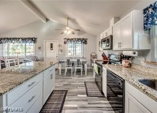 a large kitchen with granite countertop lots of counter top space and stainless steel appliances