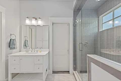 a bathroom with a double vanity sink mirror and shower
