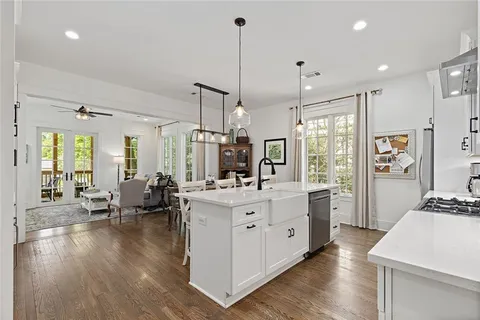 a large white kitchen with lots of counter space wooden floor and appliances