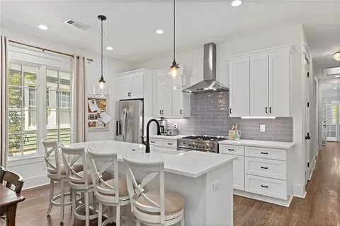 a kitchen with granite countertop a sink stainless steel appliances and window