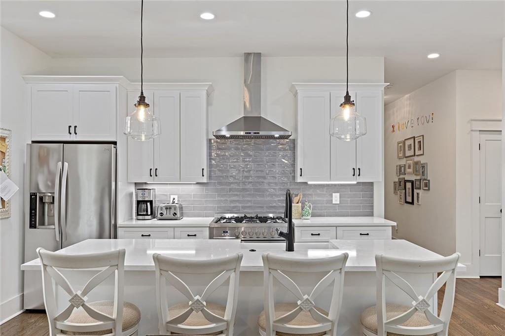221 3rd Avenue Decatur, GA 30030 - Photo 22 of 37 a kitchen with stainless steel appliances kitchen island granite countertop a refrigerator a stove a kitchen island with a dining table and chairs