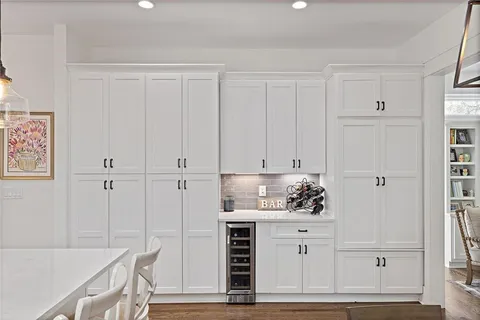a kitchen with white cabinets and white appliances