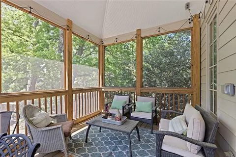 a balcony with couple of chairs and a wooden floor