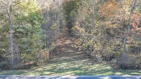 a spacious bedroom with a bed and wooden floor