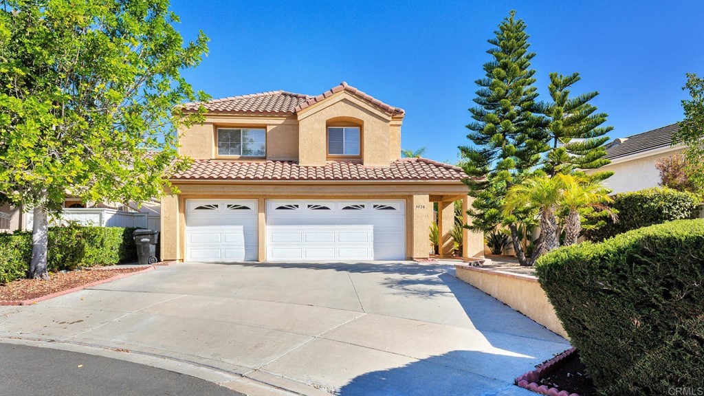 5979 Corte Playa Pacifica San Diego, CA 92124 - Photo 2 of 38 a front view of a house with a yard and garage