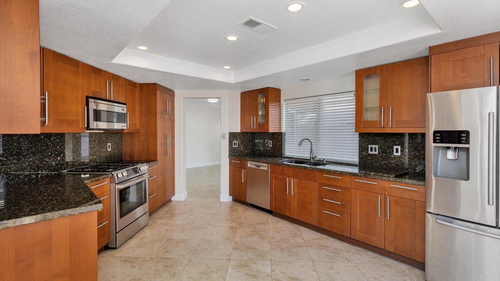 5979 Corte Playa Pacifica San Diego, CA 92124 - Photo 12 of 38 a kitchen with stainless steel appliances granite countertop a stove top oven a sink and dishwasher