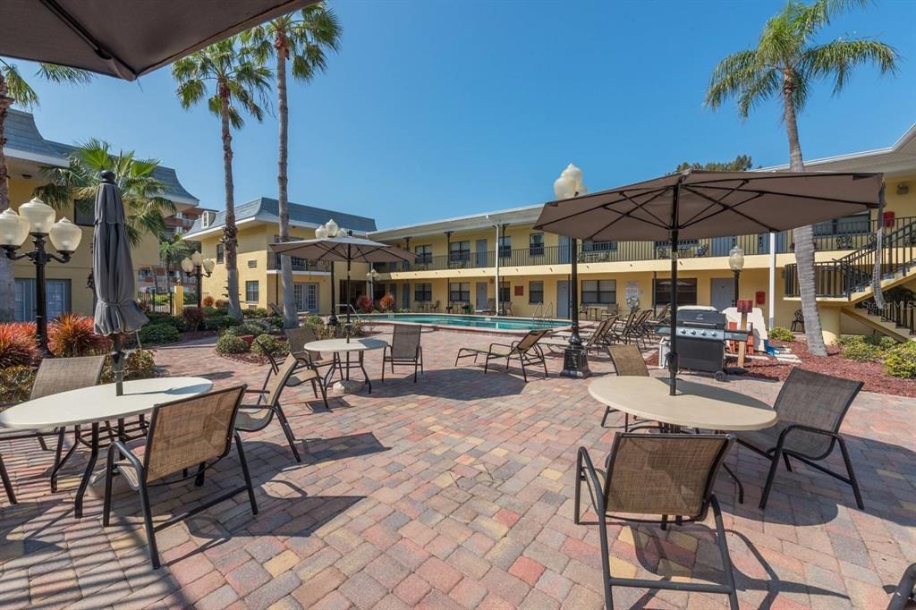 16333 Gulf Boulevard, Unit 204 Redington Beach, FL 33708 - Photo 20 of 43 a view of a patio with a table and chairs under an umbrella